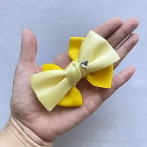 Dettaglio del fiocco giallo a tre strati con strass a forma di cuore al centro