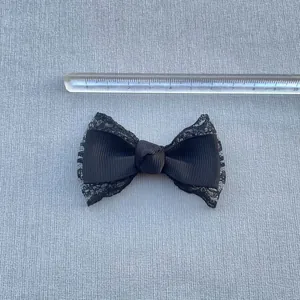 Close-up of handmade 7.5cm black grosgrain ribbon and lace bow for DIY crafts