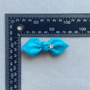 Sky blue grosgrain ribbon bow with star detail, showing 5.5cm width on a ruler scale