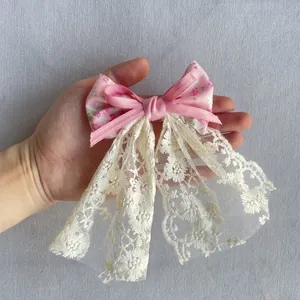 Détail d'un nœud Lolita avec ruban à fleurs roses et large ruban en dentelle blanche