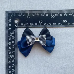 Navy and black multi-layer mesh bow hair accessory with houndstooth detail and scale