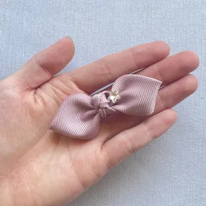 Detailed macro of a purple ribbed fabric bow with a sparkling star rhinestone center