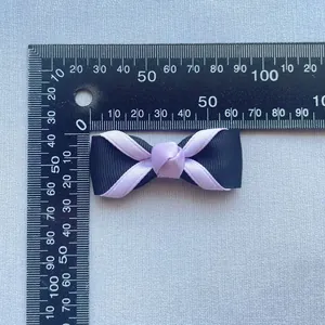 Dettaglio del fiocco fatto a mano da 5cm nero e lavanda con righello graduato