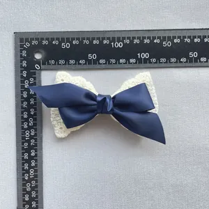 Detail einer 10cm doppelten Schleife mit dunkelblauem Band und weißer Spitze