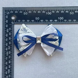 Detailed view of large navy blue mesh bow with lace and gem shown on a metric scale