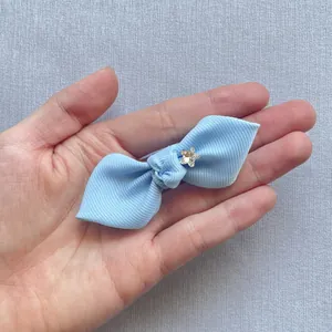 Macro shot of light blue grosgrain ribbon bow with a star-shaped rhinestone detail