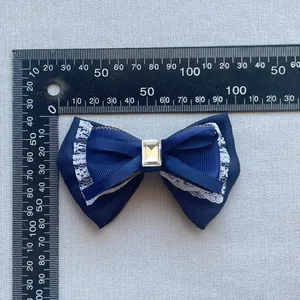 Detailed view of large dark blue mesh bow with white lace trim and crystal center