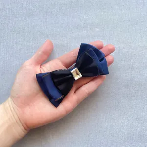 Detailed view of multilayer mesh bow accessory with navy ribbon and central crystal