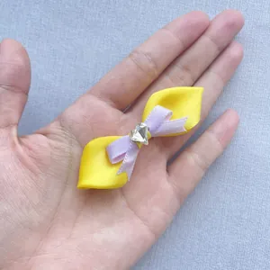 Makroaufnahme einer handgefertigten gelben lila Satinschleife mit herzförmigem Kristall