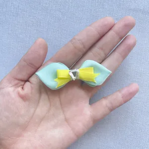 Detail einer mehrlagigen grünen und gelben Strass-Schleife für Kleidung und Taschen