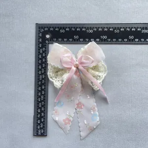 Accessoire nœud en dentelle crème et ruban rose avec rubans floraux et perle