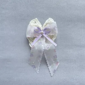Détail du nœud en dentelle avec ruban floral, nœud en satin et perle centrale élégante