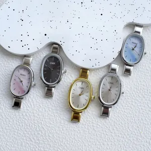 Close-up of assorted oval quartz watches with colorful sunray and mop dials on metal bands