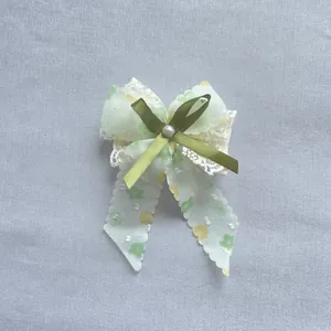 Vue détaillée du nœud en tulle floral avec bordure en dentelle blanche et perle nacrée