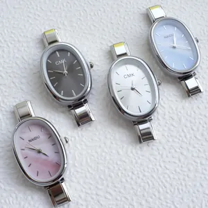 Macro view of modular quartz watches with oval dials and polished silver metal bracelets