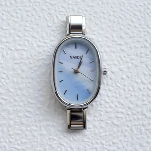 Minimalist silver oval quartz watch with light blue marble dial and polished metal strap