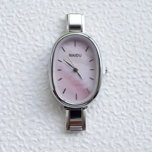 Macro shot of oval pink mother-of-pearl dial and silver stainless steel link bracelet