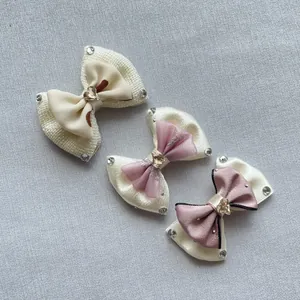 Detailed view of handmade bow hair clips with heart crystals and sparkling rhinestones