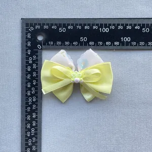 Floral bow accessory with blue print and berry detail measuring 6.5cm wide for hair or bags