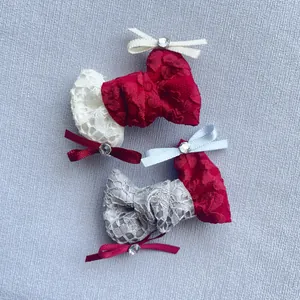 Dettaglio di fermagli per capelli a calza di Natale in pizzo con fiocchi e strass