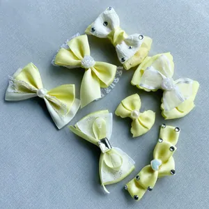 Set of 7 pale yellow handmade bow hair clips with pearls, crystals and lace details