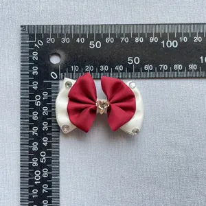 Detail view of red and white bow hair accessory with heart crystal and size measurement
