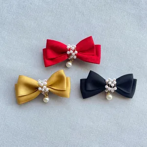 Detail von Satin-Schleifenanhängern mit Perlenreihe und eleganten Tropfenperlen