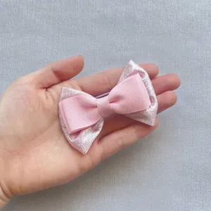 Dettaglio del fiocco per capelli rosa a doppio strato con pizzo e paillettes lucide