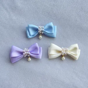 Detailansicht der Satin-Schleifen mit Perlen in Blau, Lila und Creme-Farben