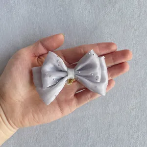Detailed view of silver satin bow with pearl pendant for DIY hair accessory making