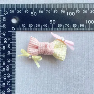 Dettagli e dimensioni dei fiocchi in tessuto rosa e crema con accenti di strass