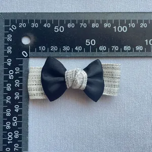 Detailed view showing 60mm handmade fabric bow accessory with a linen texture center