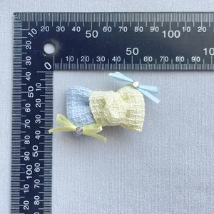 Dettaglio macro di fiocchi in tessuto fatti a mano con strass e scala graduata