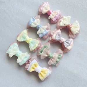 Dettaglio di 7 fiocchi fatti a mano in organza e raso dai colori pastello macaron