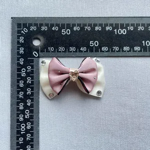 Macro shot of handmade double-layered satin bow with heart rhinestone measuring 45mm x 30mm