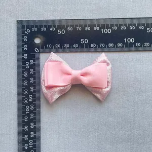 Dettaglio del fiocco rosa a doppio strato in pizzo con misure su un righello