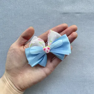 Close-up of blue satin and floral tulle bow accessory with cute pink strawberry detail