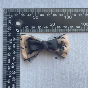 Handmade floral fabric bow with black mesh layers and center ribbon for DIY accessories