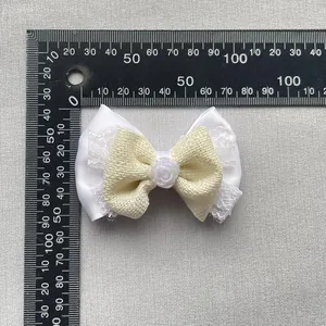 Detail of DIY beige fabric bowknot accessory with lace, satin, and small pearl rose