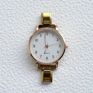 Vista dall'alto dettagliata di orologio al quarzo dorato con quadrante bianco e cinturino