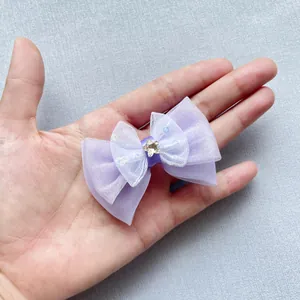 Dettaglio di un fiocco in rete lilla fatto a mano con stelle glitterate nella mano