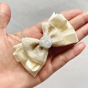 Detail of beige fabric bow with an iridescent white rose center for DIY hair accessories