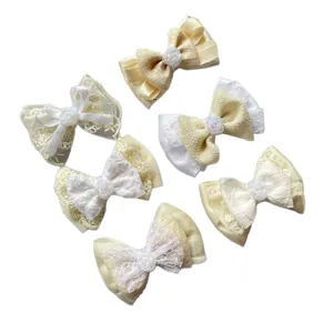 Set of 6 beige and cream lace bow hair clips with resin rose details on white background
