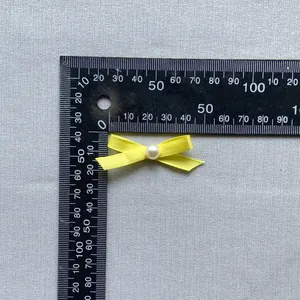 Yellow ribbon bow with white pearl centerpiece for cake decor and DIY crafts, 35mm wide