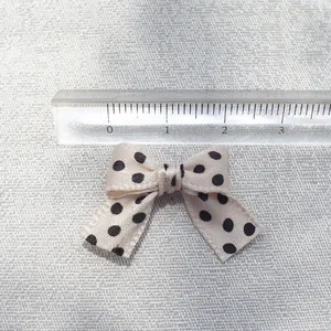 Polka dot cotton bow accessory with a ruler measuring approximately 3cm width