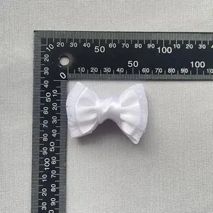 White double-layered satin ribbon bow 40mm x 30mm measurement on a textured grey background