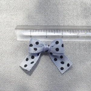 Close-up of light blue polka dot DIY bow accessory with ruler showing 3cm width scale