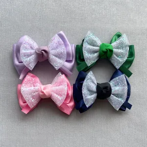 Detail von vier bunten Tüllschleifen in Lila, Grün, Rosa und Blau mit Pailletten