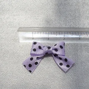 Detail shot of a 3cm light purple polka dot ribbon bow with a transparent ruler