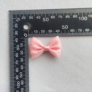 Detalle de lazo de malla rosa con lentejuelas plateadas y escala de 35 mm
